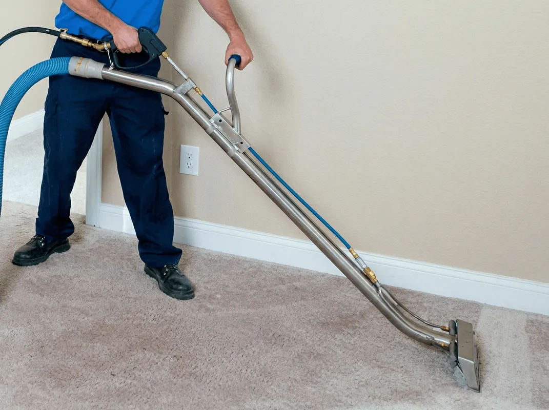 Professional operating a liquid removal machine on a carpeted floor in Grand Rapids, MI